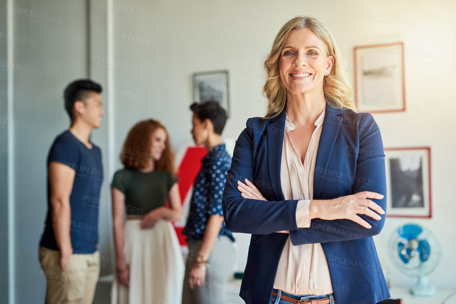 Buy stock photo Portrait of a creative employee while her colleagues are in the background in a modern office