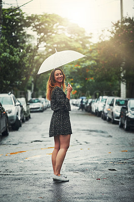 Buy stock photo Shot of a beautiful young woman walking in the rain outside