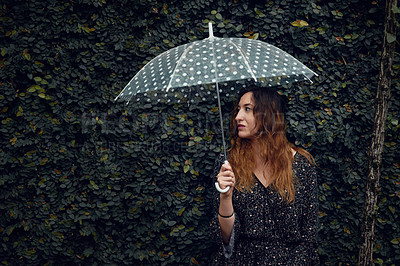 Buy stock photo Cropped shot of a beautiful young woman holding an umbrella outside