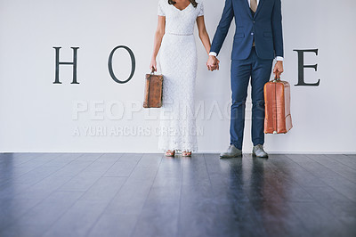 Buy stock photo Concept studio shot of a bride and groom making an M in the word “home” against a wall