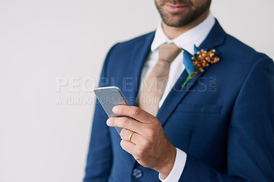 Buy stock photo Cropped studio shot of a stylish groom using a mobile phone against a gray background
