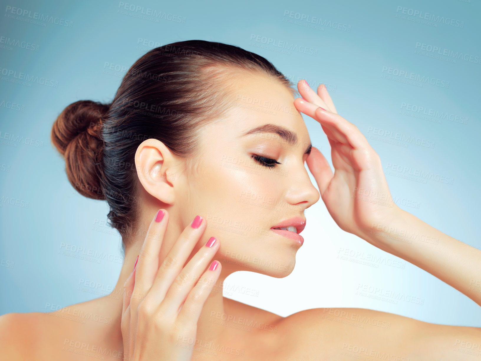 Buy stock photo Studio shot of a beautiful young woman feeling her skin against a blue background