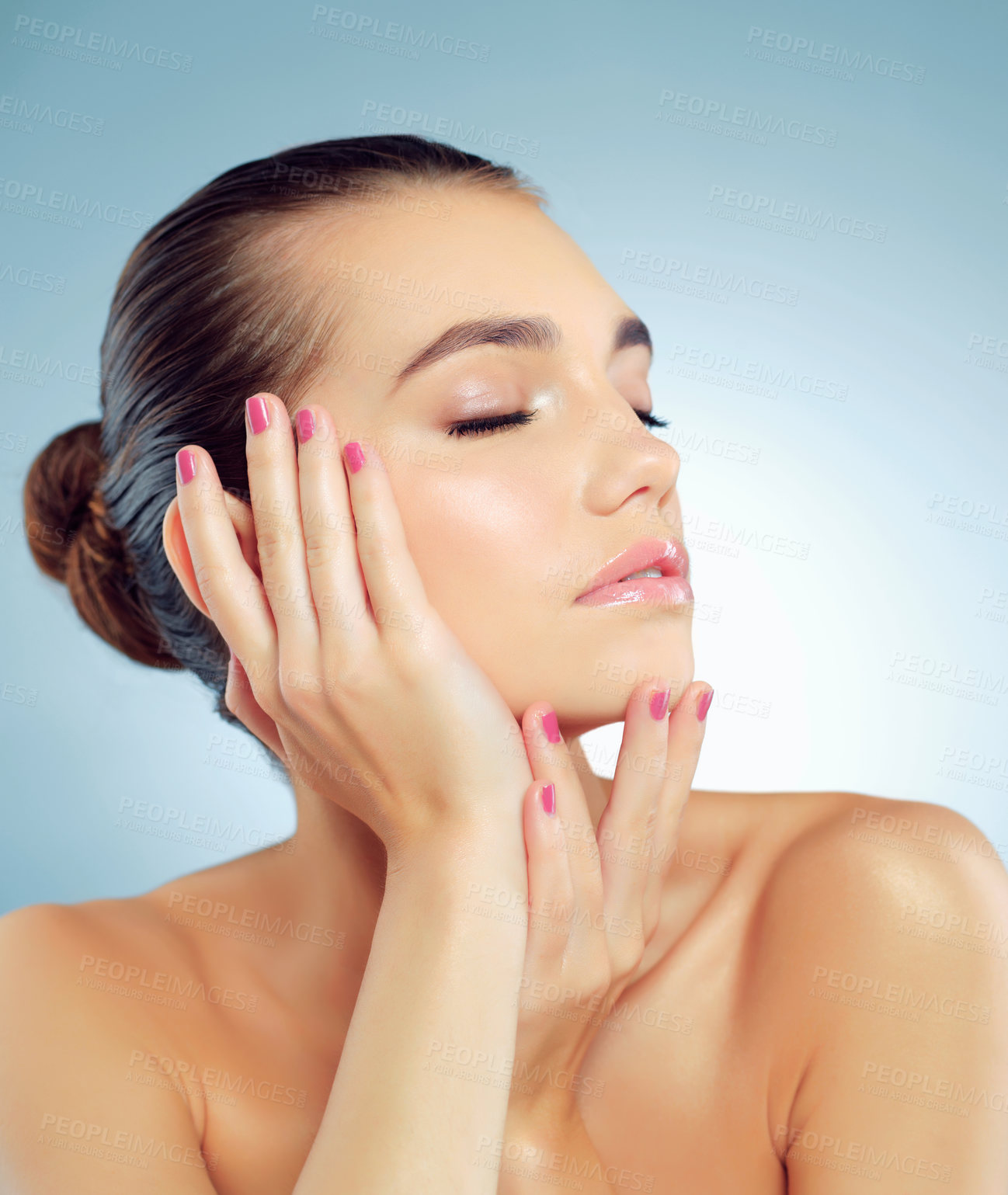 Buy stock photo Studio shot of a beautiful young woman feeling her skin against a blue background