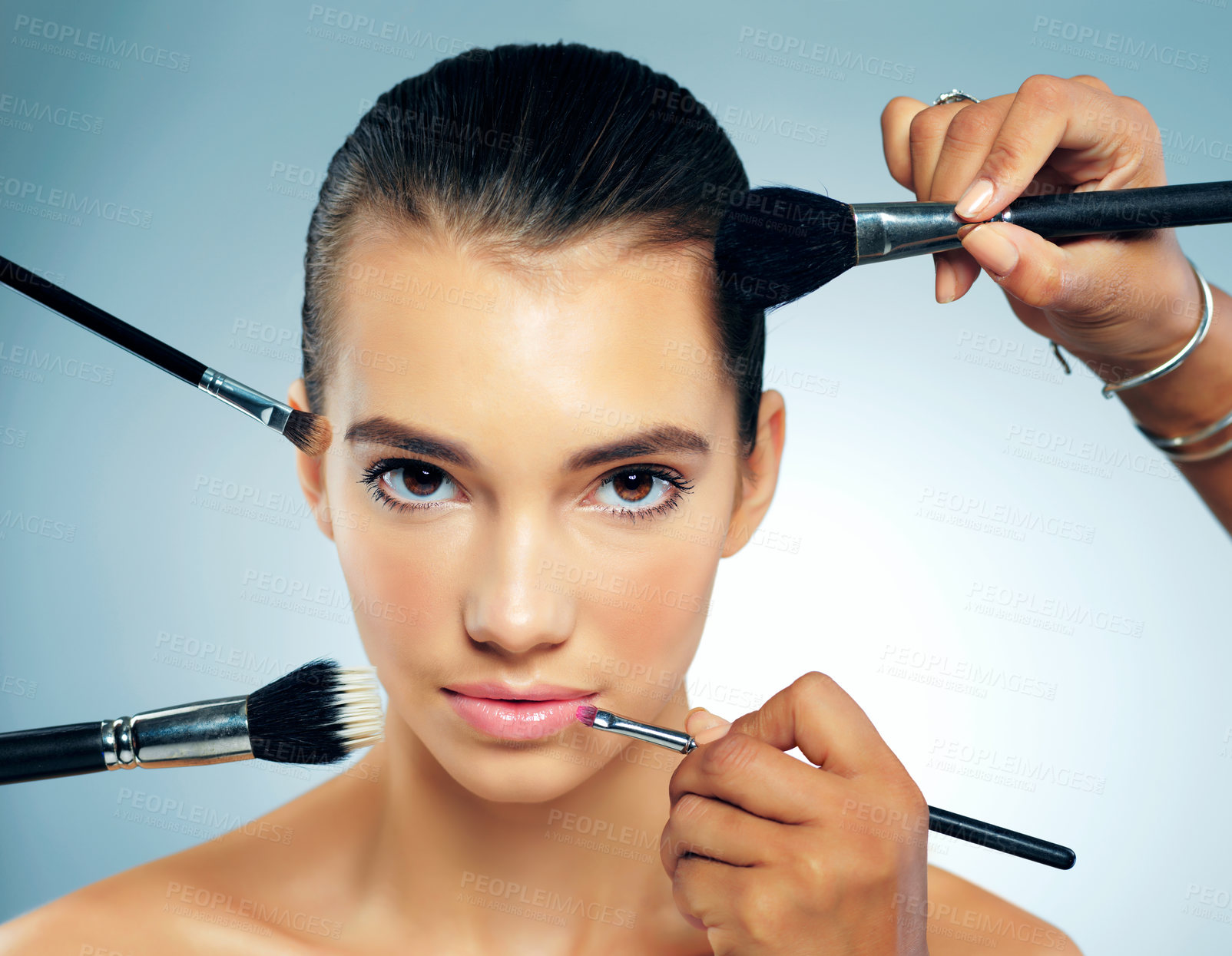 Buy stock photo Portrait, makeup and woman with brushes, hands and dermatology on blue studio background. Face, person and model with beauty, grooming or shine with cosmetics, aesthetic and skincare with smooth skin
