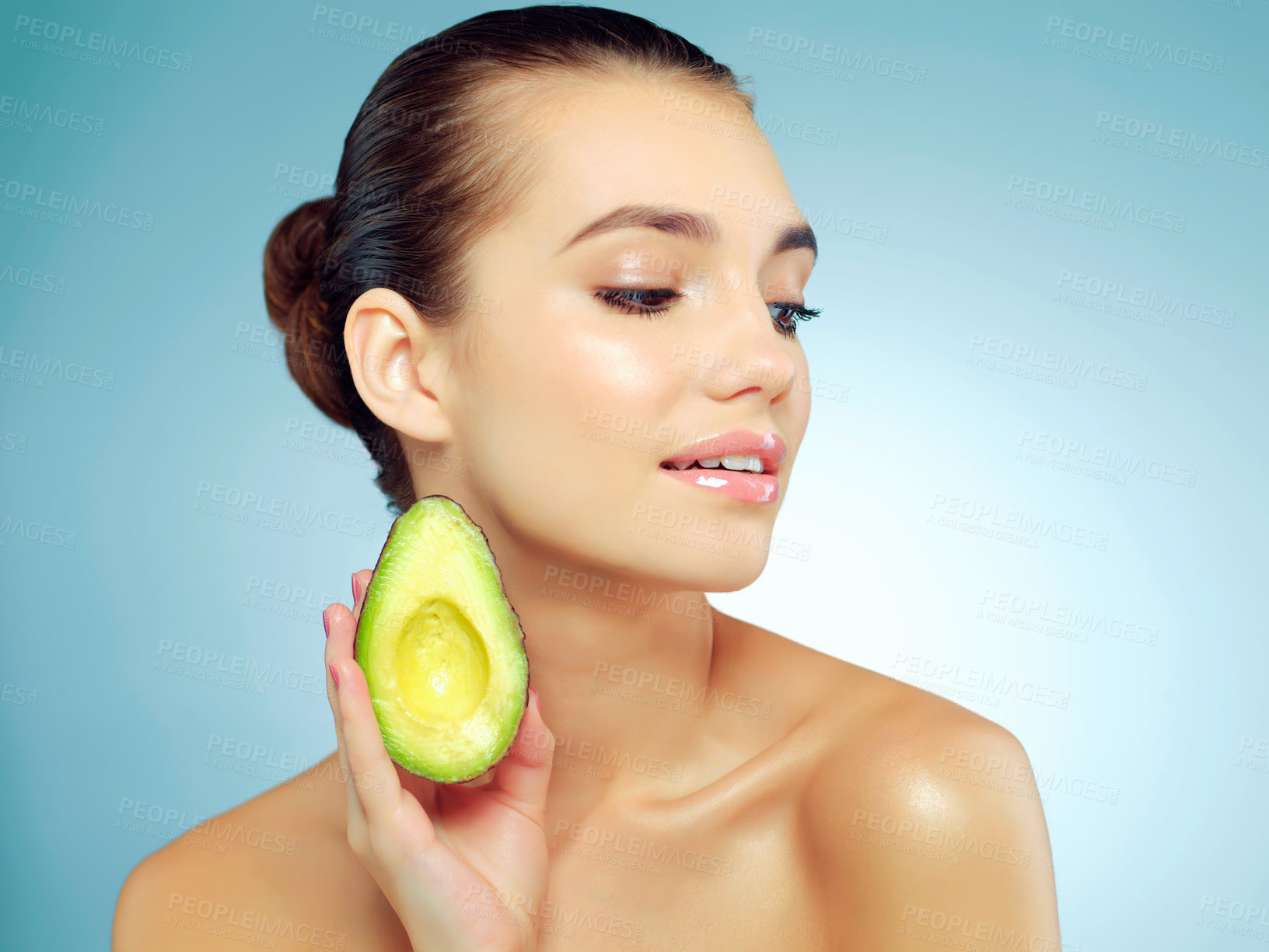 Buy stock photo Avocado, skincare and woman in studio with natural, organic and face routine with health. Beauty, wellness and female person with nutrition fruit for facial dermatology treatment by blue background.