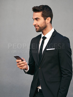 Buy stock photo Business man, phone and smile with confidence, idea and social media break in studio. Suit, corporate and executive fashion with mobile networking, worker and professional style with gray background