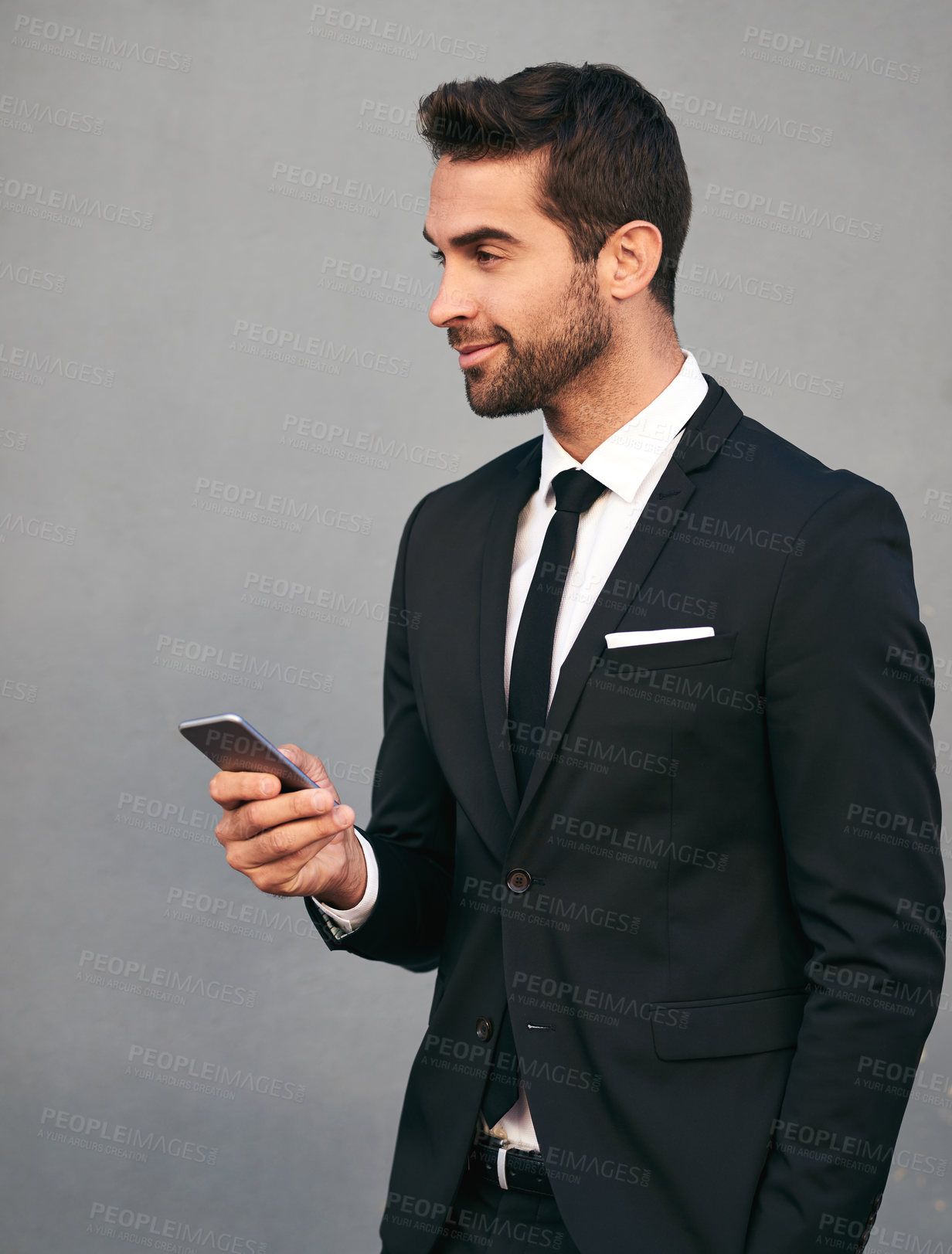 Buy stock photo Business man, phone and smile with confidence, idea and social media break in studio. Suit, corporate and executive fashion with mobile networking, worker and professional style with gray background