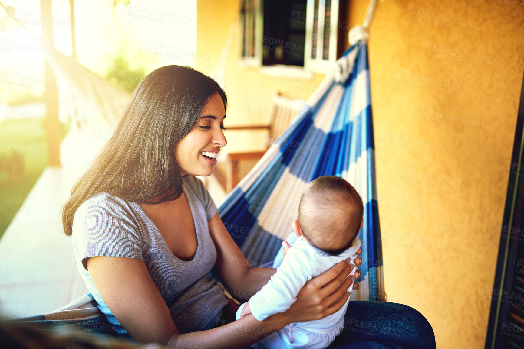 Buy stock photo Happy, woman and holding baby outdoor for playful bonding, family security and communication at house. Smile, mother and newborn with sunshine, morning care and safety support for child development