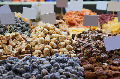 Buy stock photo Shot of a wide variety of different types of delicious treats at a market stall outside during the day