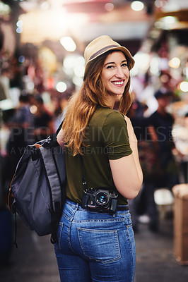 Buy stock photo Shot of a cheerful young woman walking around in a busy market outside during the day