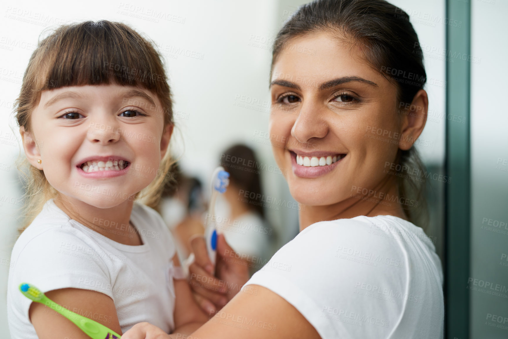 Buy stock photo Portrait of a mother and daughter brushing their teeth together in the bathroom at home