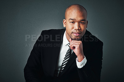 Buy stock photo Studio shot of a handsome young businessman posing against a gray background