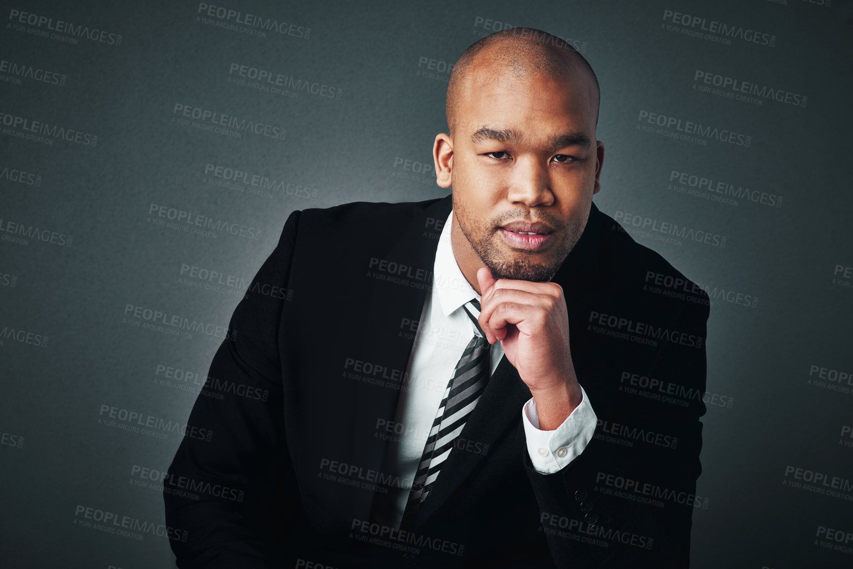 Buy stock photo Studio shot of a handsome young businessman posing against a gray background