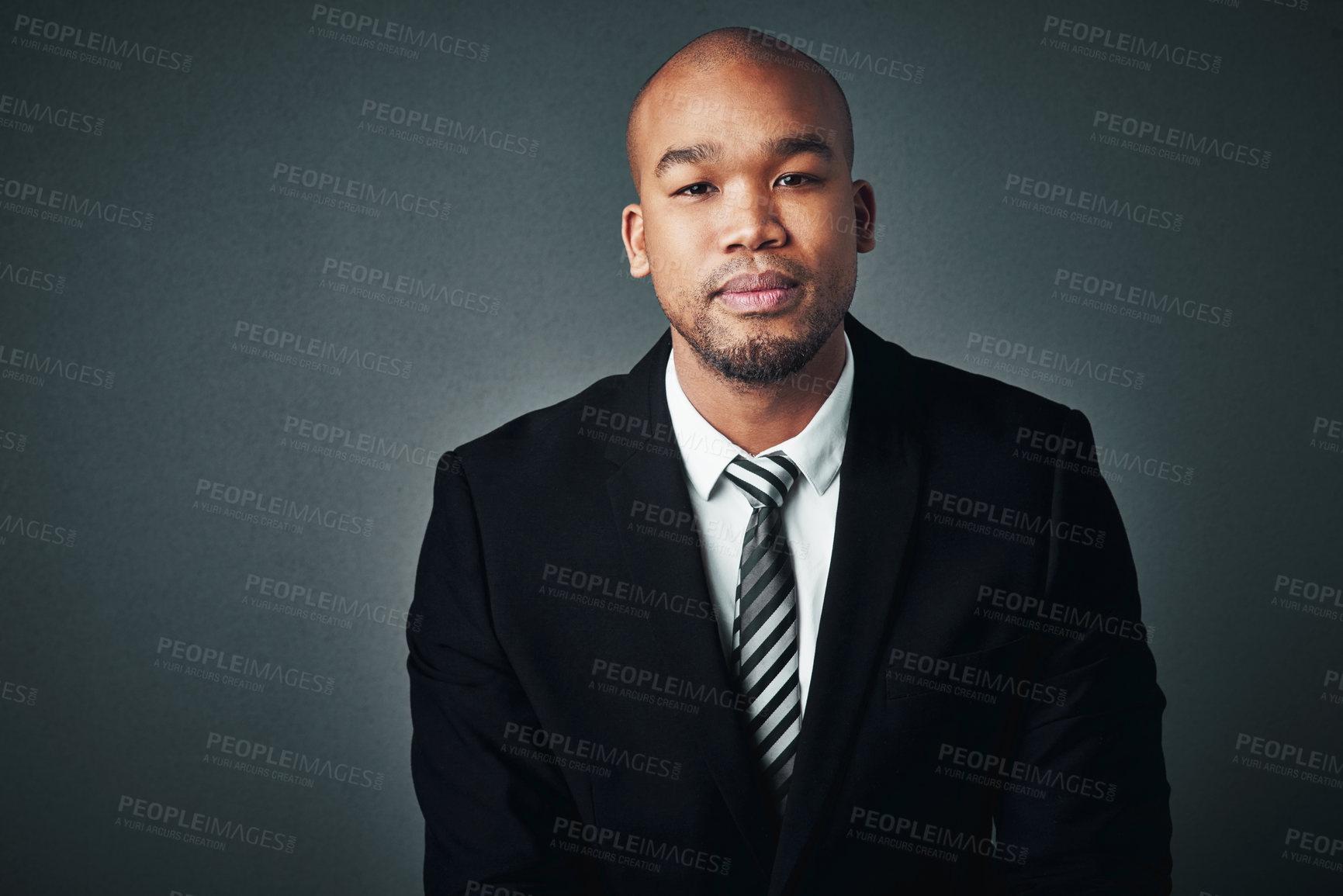 Buy stock photo Studio shot of a handsome young businessman posing against a gray background