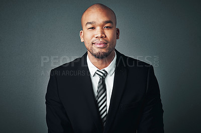 Buy stock photo Studio shot of a handsome young businessman posing against a gray background