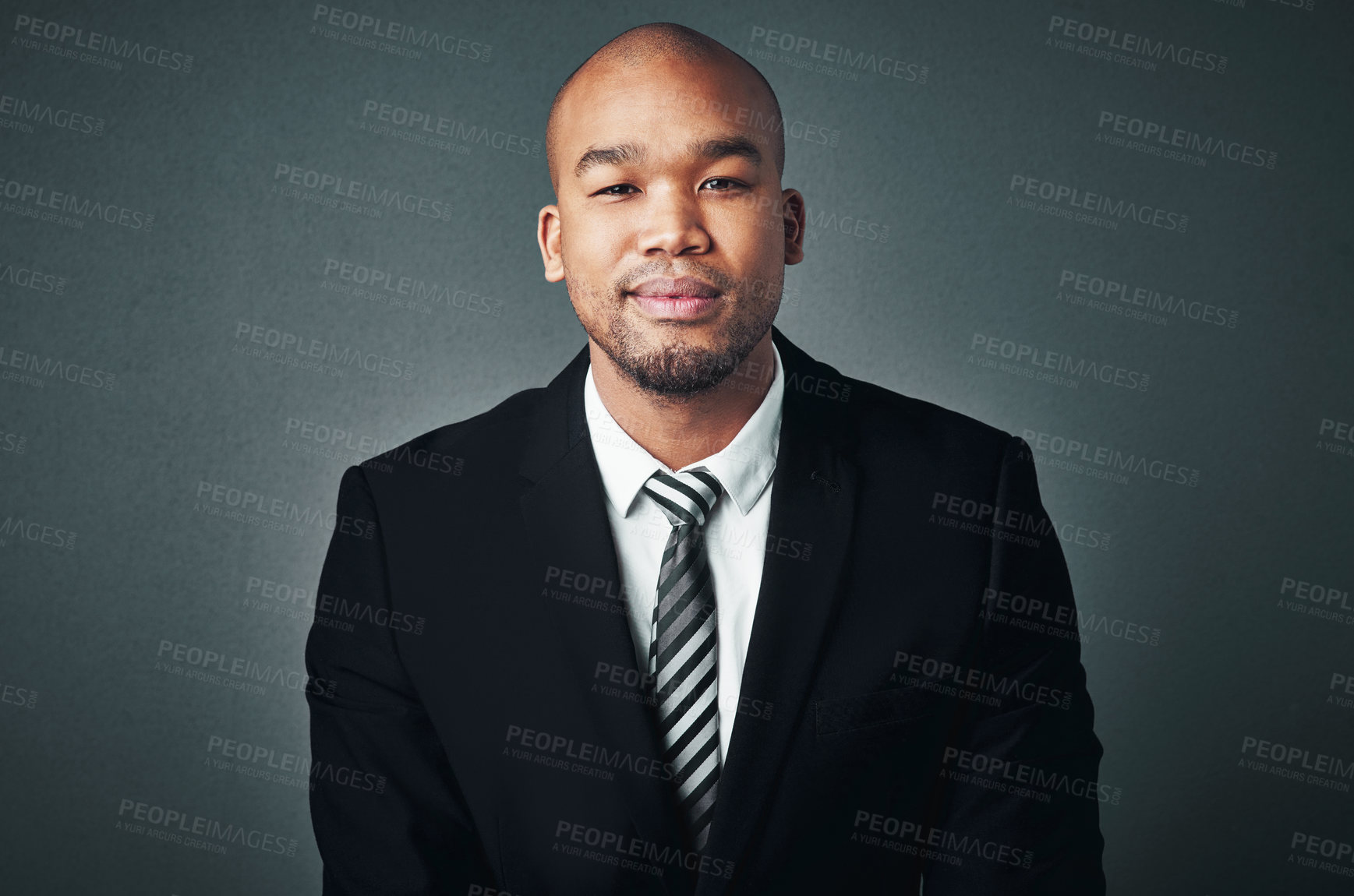 Buy stock photo Studio shot of a handsome young businessman posing against a gray background