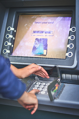 Buy stock photo Cropped shot of a woman entering her pin code at an ATM