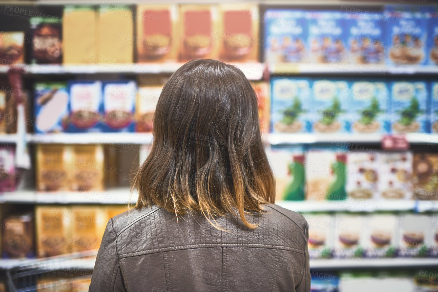 Buy stock photo Rearview shot of a young woman shopping at a grocery store