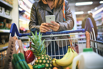 Buy stock photo Trolley, shopping and hands of woman with phone for healthy food, website and information on items. Happy, person and customer with tech in supermarket for grocery list, app and checking ingredients