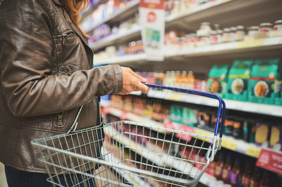 Buy stock photo Basket, hand and shelves of person in grocery store for purchase, retail or shopping closeup. Food, groceries and products with customer person in supermarket for offer, sales price or service