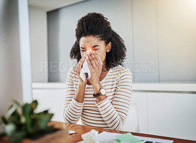 Buy stock photo Shot of a young woman blowing her nose while working at home
