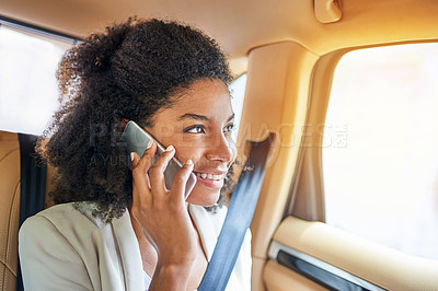 Buy stock photo Shot of an attractive young businesswoman making a phonecall while being driven to work on her morning commute