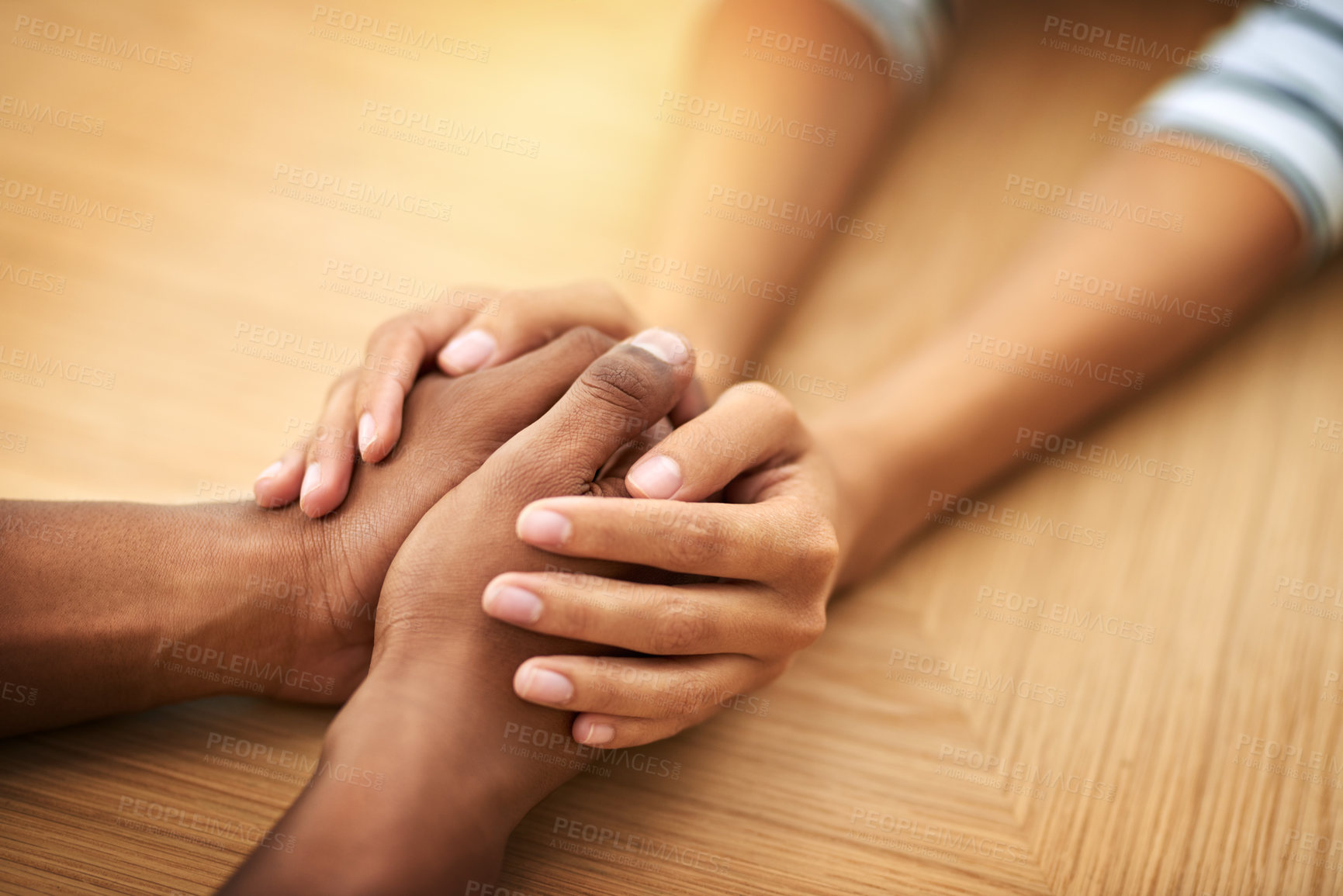 Buy stock photo People, holding hands and care with sympathy for support, trust or understanding on wooden table. Closeup, interracial or touch with empathy for listening, grief or loss in hope or faith together