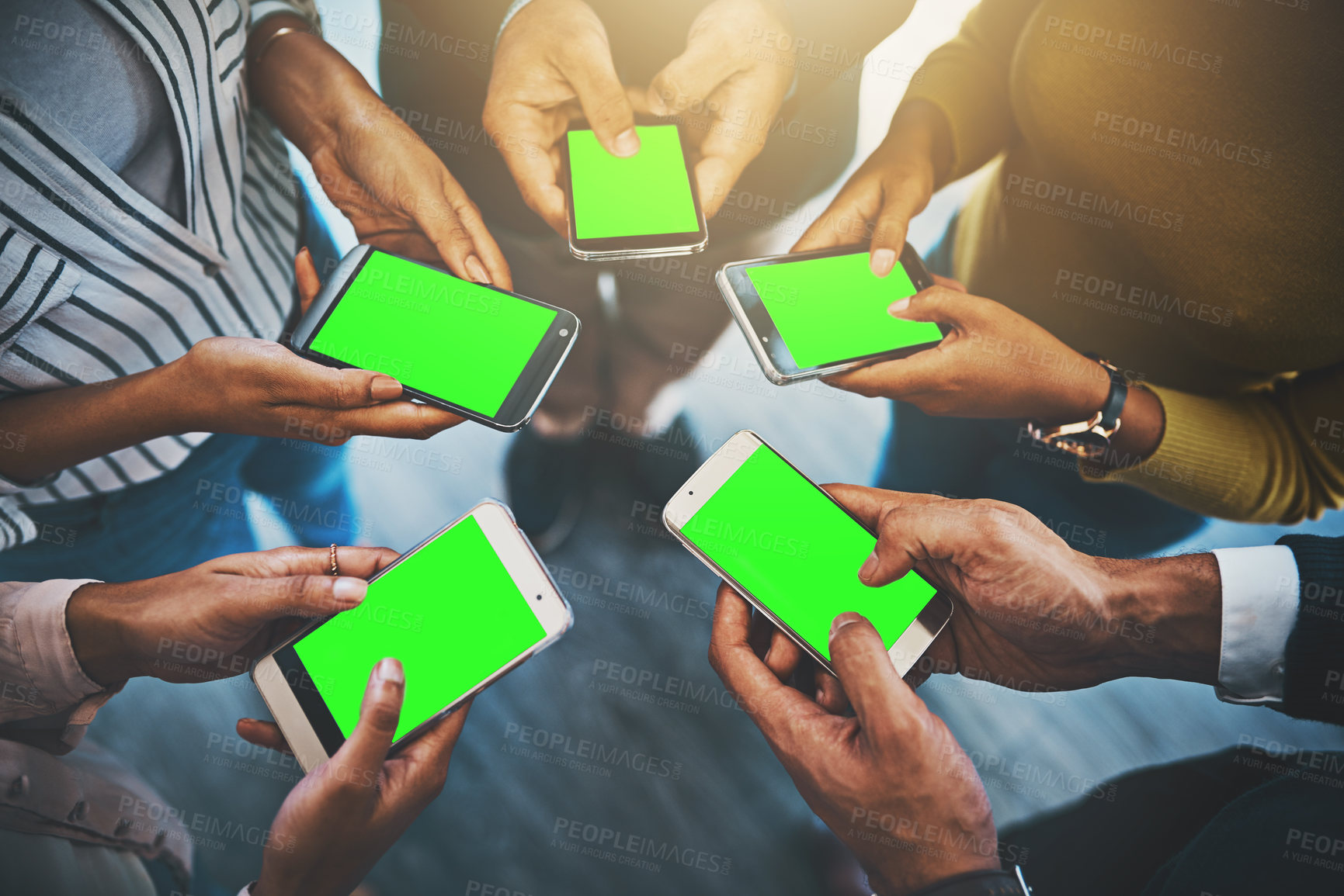 Buy stock photo Closeup shot of an unrecognizable group of businesspeople using their cellphones in synchronicity