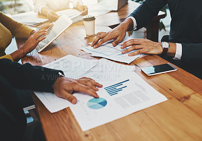 Buy stock photo Closeup shot of an unrecognizable group of businesspeople going through paperwork in an office