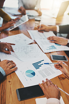 Buy stock photo Closeup shot of an unrecognizable group of businesspeople going through paperwork in an office