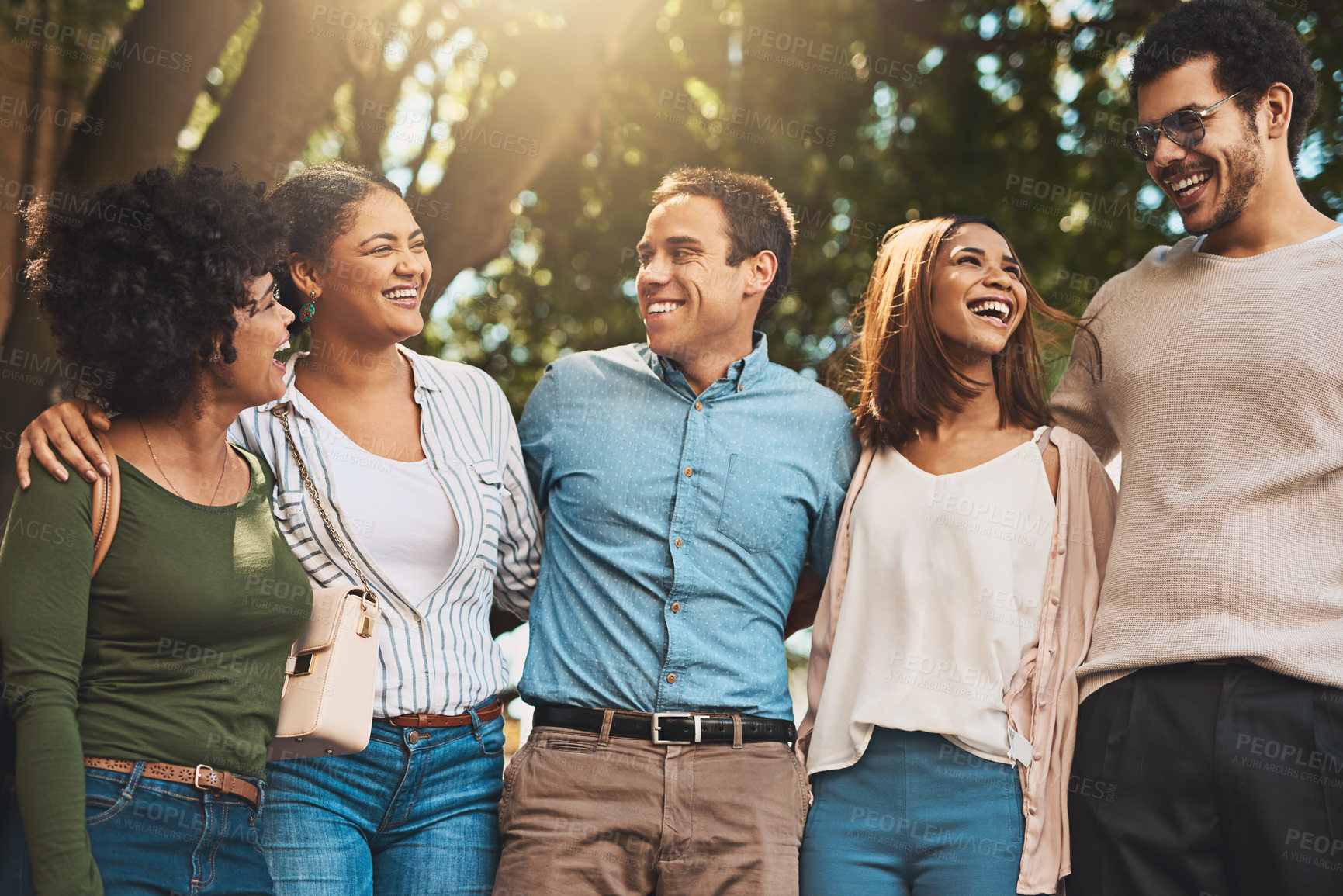 Buy stock photo Shot of a cheerful young group of friends standing together while looking at the camera outside during the day