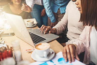 Buy stock photo Shot of a group of unrecognizable people working on a laptop together while being seated at a coffeeshop outside during the day