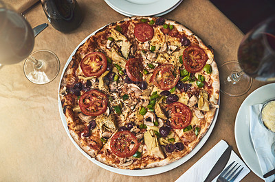 Buy stock photo High angle shot of a full plate of pizza resting on top of a table inside of a restaurant during the day