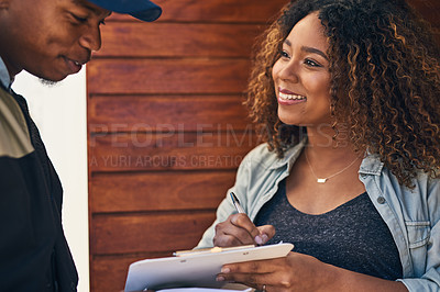Buy stock photo Shot of a woman signing for her delivery from the courier