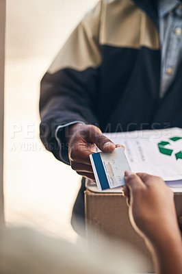 Buy stock photo Closeup shot of a courier accepting a credit card payment from a customer for a delivery