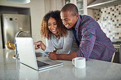 Buy stock photo Cropped shot of an affectionate young couple using a laptop in their kitchen at home