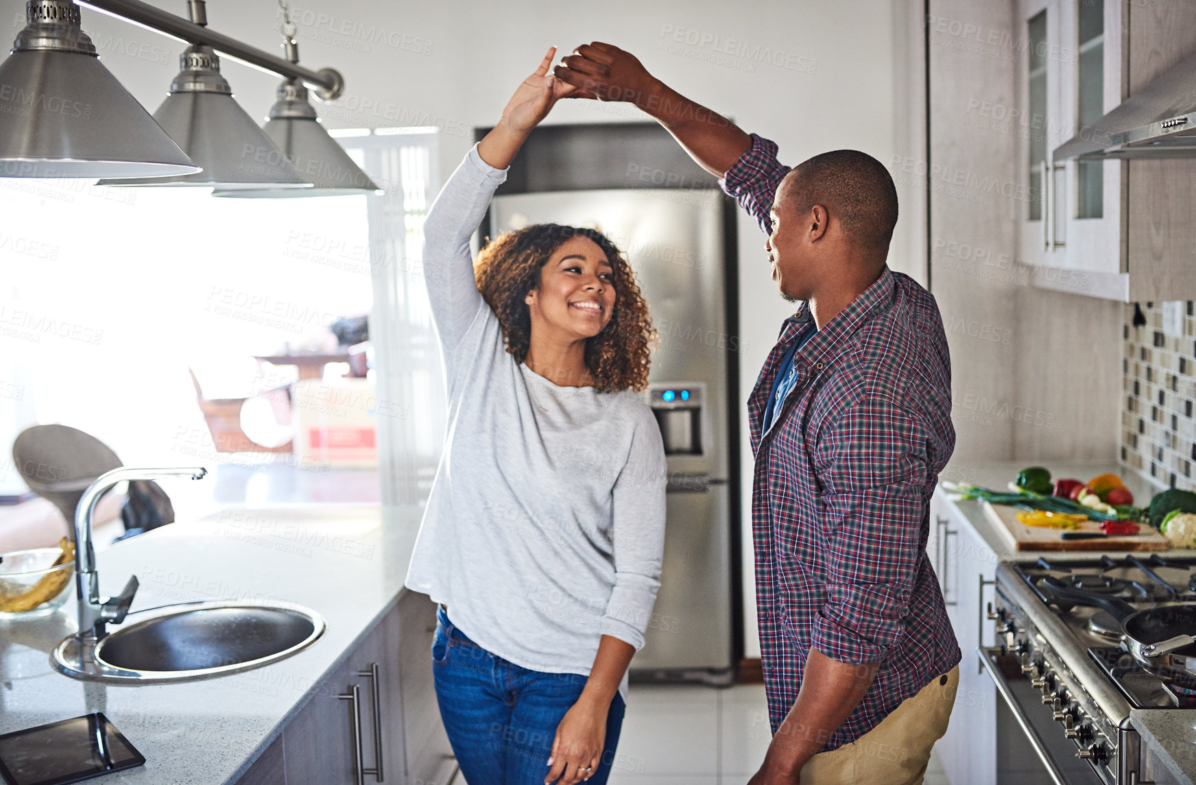 Buy stock photo Cropped shot of an affectionate young couple dancing in their kitchen at home