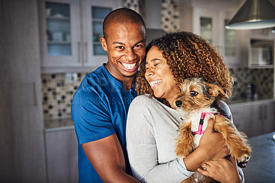 Buy stock photo Cropped shot of an affectionate young couple standing with their puppy in the kitchen at home