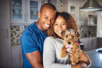 Buy stock photo Cropped portrait of an affectionate young couple standing with their puppy in the kitchen at home