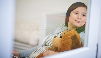 Buy stock photo Cropped shot of an attractive young woman relaxing with a teddy bear on the sofa at home