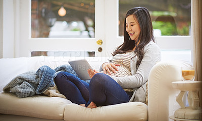 Buy stock photo Shot of a pregnant woman using a digital tablet at home