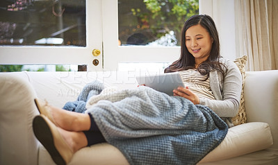 Buy stock photo Shot of a pregnant woman using a digital tablet at home