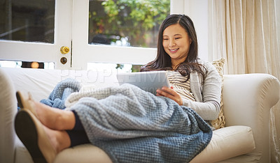 Buy stock photo Shot of a pregnant woman using a digital tablet at home