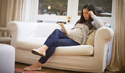 Buy stock photo Shot of a pregnant woman reading a book at home