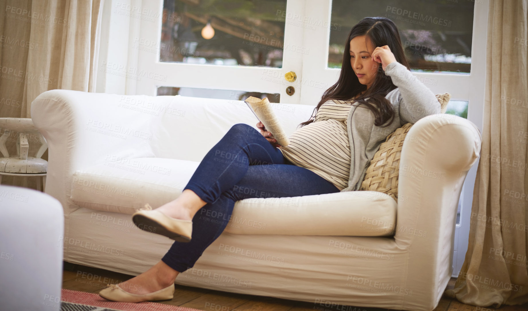 Buy stock photo Shot of a pregnant woman reading a book at home