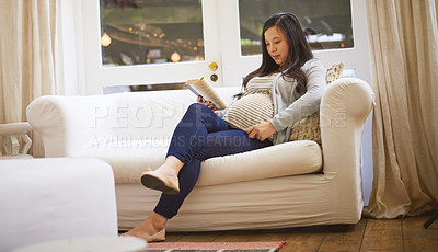 Buy stock photo Shot of a pregnant woman reading a book at home