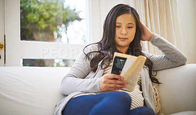 Buy stock photo Shot of a pregnant woman reading a book at home