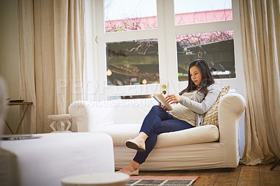 Buy stock photo Shot of a pregnant woman reading a book at home