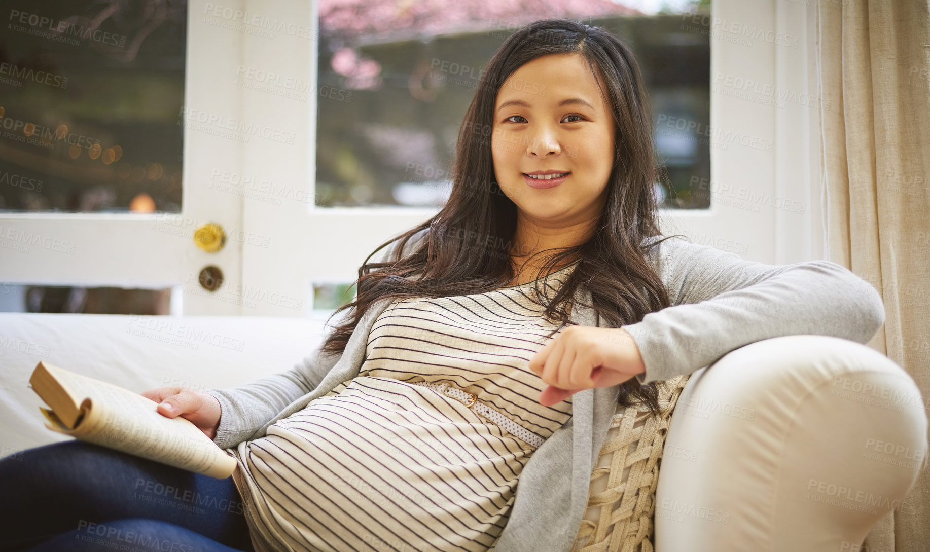 Buy stock photo Portrait of a pregnant woman reading a book at home