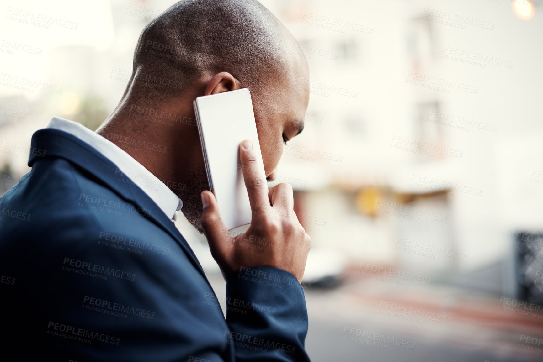 Buy stock photo Shot of a handsome young businessman talking on a cellphone outside his office